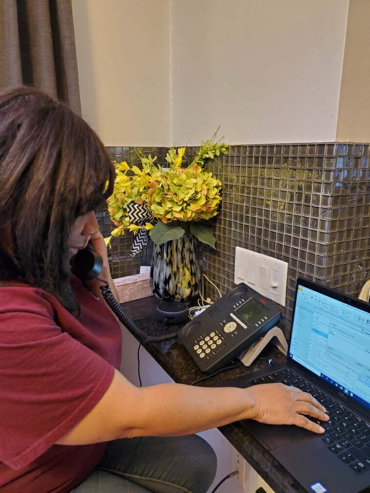 Andrea at Work | A Detroit Area Agency on Aging employee on the phone and computer | Information & Assistance